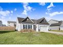 Modern two-story house with gray and white exterior, two car garage and grassy yard at 142 Jade St, Smithfield, NC 27577