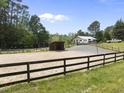 Outdoor horse paddock with well maintained fencing, and horse sheds with covered areas at 265 Verde Rd, Apex, NC 27523