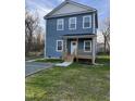Charming two-story home with light blue siding, covered front porch, and a gravel driveway at 343 Foster St, Burlington, NC 27217