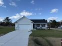 Newly constructed home with a white exterior, gray roof, and a two-car garage at 75 Shiloh Dr, Lillington, NC 27546