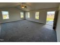 Spacious living room with grey carpet, neutral walls, and multiple windows at 75 Shiloh Dr, Lillington, NC 27546