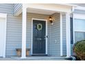 Dark-colored front door with wreath, columns, and porch light at 1134 Aster Way, Burlington, NC 27215