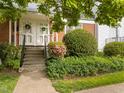 Inviting brick townhouse entrance with decorative wreaths and well-manicured greenery at 1621 Sutton Dr, Raleigh, NC 27605