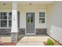 Charming front entrance with stone accents, number 18, grey door, and decorative shrubbery at 18 Hewitt Woods Dr, Clayton, NC 27527