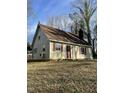 View of the side and front of the home with a brick chimney and red shutters at 2324 Lonnie Cir, Hillsborough, NC 27278