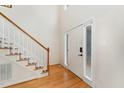 Bright foyer featuring hardwood floors, a staircase with white banisters, and a front door with sidelights at 316 Trafalgar Ln, Cary, NC 27513