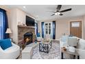 Cozy living room with a stone fireplace, ceiling fan, and large window at 402 W Clay St, Mebane, NC 27302
