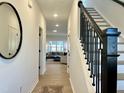 Bright hallway with hardwood floors and staircase with black iron spindles at 4321 Darius Ln # 23, Fuquay Varina, NC 27526