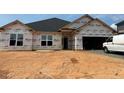New construction home featuring large windows and attached two-car garage awaiting its finishing touches and landscaping at 572 Glenkirk Pl, Garner, NC 27529
