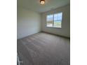 Carpeted bedroom featuring a large window offering abundant natural light at 93 Ausban Ridge Ln # 033, Four Oaks, NC 27524