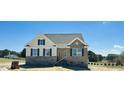Charming two-story home featuring brick accents, neutral siding, and manicured landscaping at 93 Ausban Ridge Ln # 033, Four Oaks, NC 27524