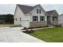 Beautiful single-Gathering home showcasing a concrete driveway and lush green lawn at 93 Ausban Ridge Ln # 033, Four Oaks, NC 27524