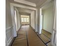 Bright hallway showcasing detailed trim work and moldings, leading to rooms with large windows at 93 Ausban Ridge Ln # 033, Four Oaks, NC 27524