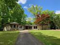 Ranch home with stone accents, large yard, and long driveway at 1126 Trailwood Dr, Raleigh, NC 27606