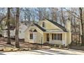 Nice yellow house with a white porch, and mature trees in the background at 1322 Cedar Branch Ct, Wake Forest, NC 27587