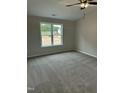 Carpeted bedroom with a ceiling fan, window with natural light, and neutral colored walls at 233 N Movado Trl, Kenly, NC 27542
