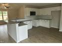 New kitchen features white cabinets, stainless microwave, granite counters, a breakfast bar, and new appliances at 233 N Movado Trl, Kenly, NC 27542