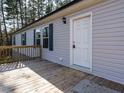 Front entrance of the home with a white door and wooden deck at 3050 Bennett Siler City Rd, Bennett, NC 27208