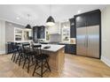 Spacious kitchen showcases an oversized island, stainless steel refrigerator, dark cabinets, and hardwood floors at 3317 Hampton Rd, Raleigh, NC 27607
