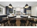 Modern kitchen boasts a large island, black cabinetry, stainless steel appliances, and stylish pendant lighting at 3317 Hampton Rd, Raleigh, NC 27607