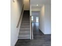 Modern staircase with dark hardwood floors and carpeted steps at 40 Shay St, Angier, NC 27501