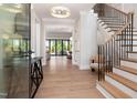 Bright foyer featuring wood floors, a staircase with black railings, and access to living areas at 4005 Brevard Pl, Raleigh, NC 27609