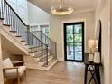 Bright foyer with stairs, modern light fixture, and view to the front door at 4005 Brevard Pl, Raleigh, NC 27609
