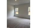 Bright bedroom with carpeted floors and two windows at 507 Barnes Landing Dr, Four Oaks, NC 27524