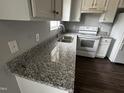 Modern kitchen featuring granite countertops and white cabinetry at 637 Waterford Dr, Clayton, NC 27520