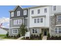 Two-story townhome with gray and white siding, landscaping, and American flag at 703 Lucky Clover Way, Fuquay Varina, NC 27526