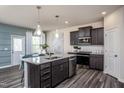 Modern kitchen with dark cabinets, granite countertops, and stainless steel appliances at 760 Denburn Pl, Raleigh, NC 27603