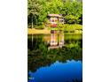 Stunning reflection of lake house on calm water at 10305 Old Creedmoor Rd, Raleigh, NC 27613