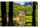 Lake house partially obscured by trees, showcasing waterfront living at 10305 Old Creedmoor Rd, Raleigh, NC 27613