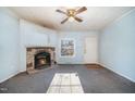 Living room featuring a stone fireplace, a window, a ceiling fan, and access to the front door at 1109 Mays Chapel Rd, Bear Creek, NC 27207