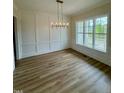Bright dining room featuring modern lighting, hardwood floors, and large window with a view at 1229 Azalea Garden Cir, Raleigh, NC 27603