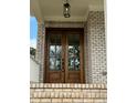Elegant wood double front doors with glass panes, framed by brick and overhead lighting at 1229 Azalea Garden Cir, Raleigh, NC 27603