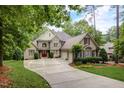 Stone house with 3-car garage and manicured lawn at 1300 Caistor Ln, Raleigh, NC 27614