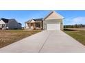 Side view of a single story home with an attached two-car garage and long concrete driveway at 137 Glenwood Pl, Kenly, NC 27542