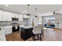 Modern kitchen with white cabinets, granite countertops, stainless steel appliances, and island with pendant lighting at 137 Glenwood Pl, Kenly, NC 27542