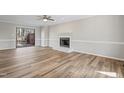 Bright living room features wood floors, fireplace, and sliding doors to outdoor deck at 4224 Sancroft Dr, Apex, NC 27539