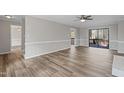 Spacious living room with wood floors, ceiling fan, and sliding glass doors to deck at 4224 Sancroft Dr, Apex, NC 27539