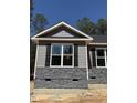 Close-up of the exterior showcasing stone accents, modern black shutters, and complementary color scheme at 65 Watermelon Dr, Franklinton, NC 27525