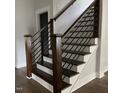 Modern staircase with wood treads, black metal railings, and white risers, blending style and functionality at 716 Spirit Hill Dr, Hillsborough, NC 27278