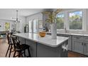 Open kitchen featuring a center island with counter seating, abundant natural light, and grey cabinetry at 727 Martin Luther King Jr Blvd Blvd, Raleigh, NC 27601