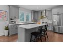 Modern kitchen featuring a central island with seating, gray cabinets, and stainless steel appliances at 727 Martin Luther King Jr Blvd Blvd, Raleigh, NC 27601