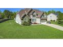 Craftsman-style home with stone accents, attached garage, and large, well-manicured lawn at 7945 Parker Mill Trail, Fuquay Varina, NC 27526