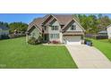 Charming two-story home boasts lush green lawn, attached garage, and attractive landscaping at 7945 Parker Mill Trail, Fuquay Varina, NC 27526
