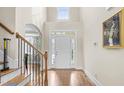 Bright foyer with hardwood floors, high ceilings, a staircase, and a front door with sidelights at 7945 Parker Mill Trail, Fuquay Varina, NC 27526