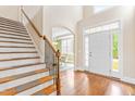 Elegant foyer featuring wood floors, a staircase, and a front door with sidelights for ample natural light at 7945 Parker Mill Trail, Fuquay Varina, NC 27526