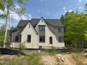 Charming two-story home featuring a mix of white brick and gray siding, black window frames, and a prominent gabled roofline at 109 Evander Way, Pittsboro, NC 27312
